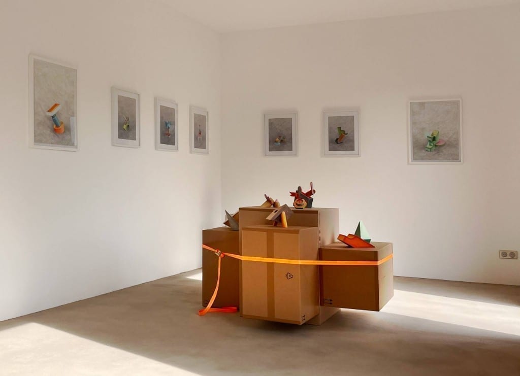 Art installation with cardboard boxes and geometric sculptures in the gallery